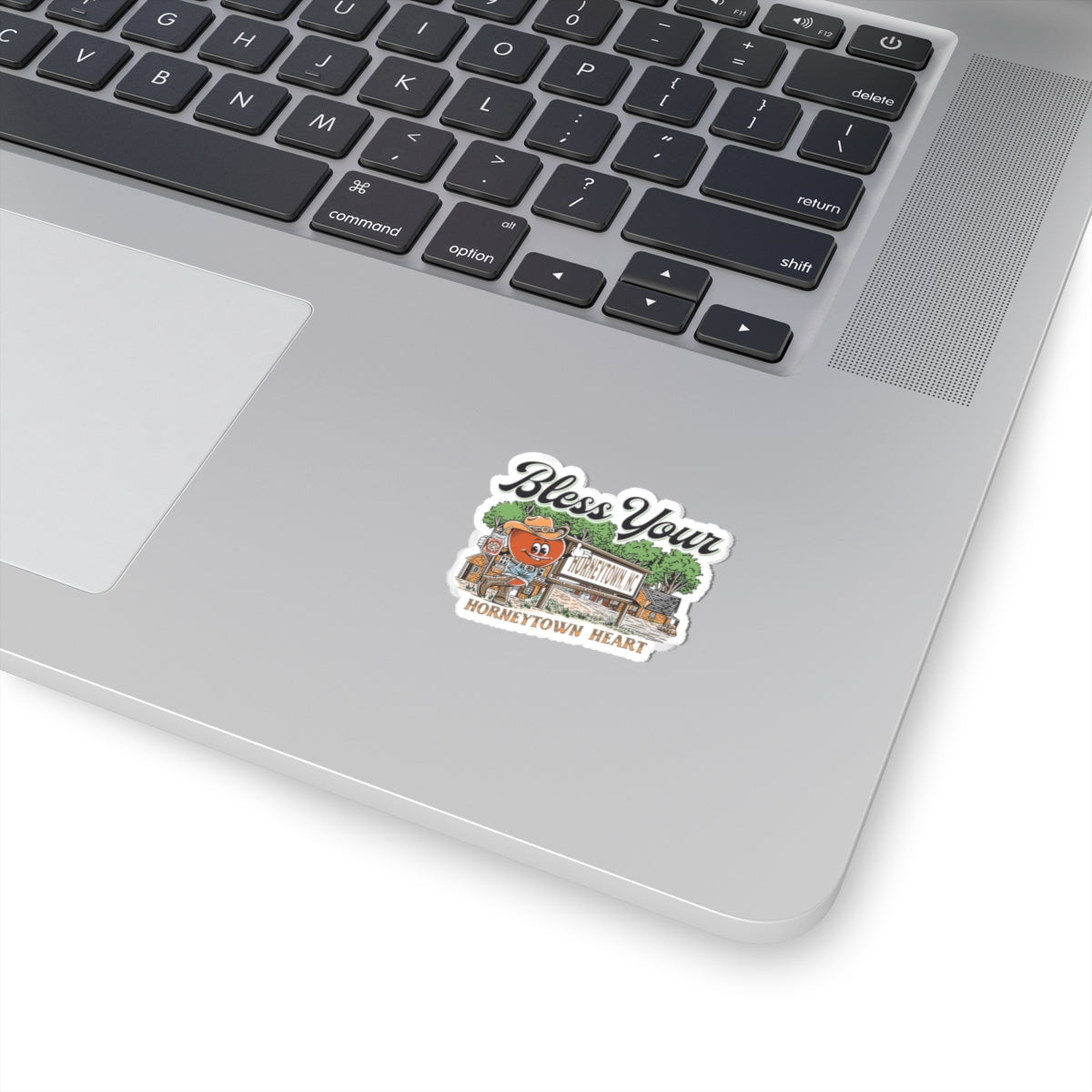 "Colorful 2x2 inch vinyl sticker featuring the playful phrase 'Bless Your Horneytown Heart' in bold, eye-catching typography. This kiss-cut sticker showcases a humorous nod to North Carolina's unique town names, with a charming design that incorporates elements of the state's natural beauty, such as lush greenery or the iconic Blue Ridge Mountains. Perfect for adding a touch of Southern charm and wit to your laptop, water bottle, or notebook."