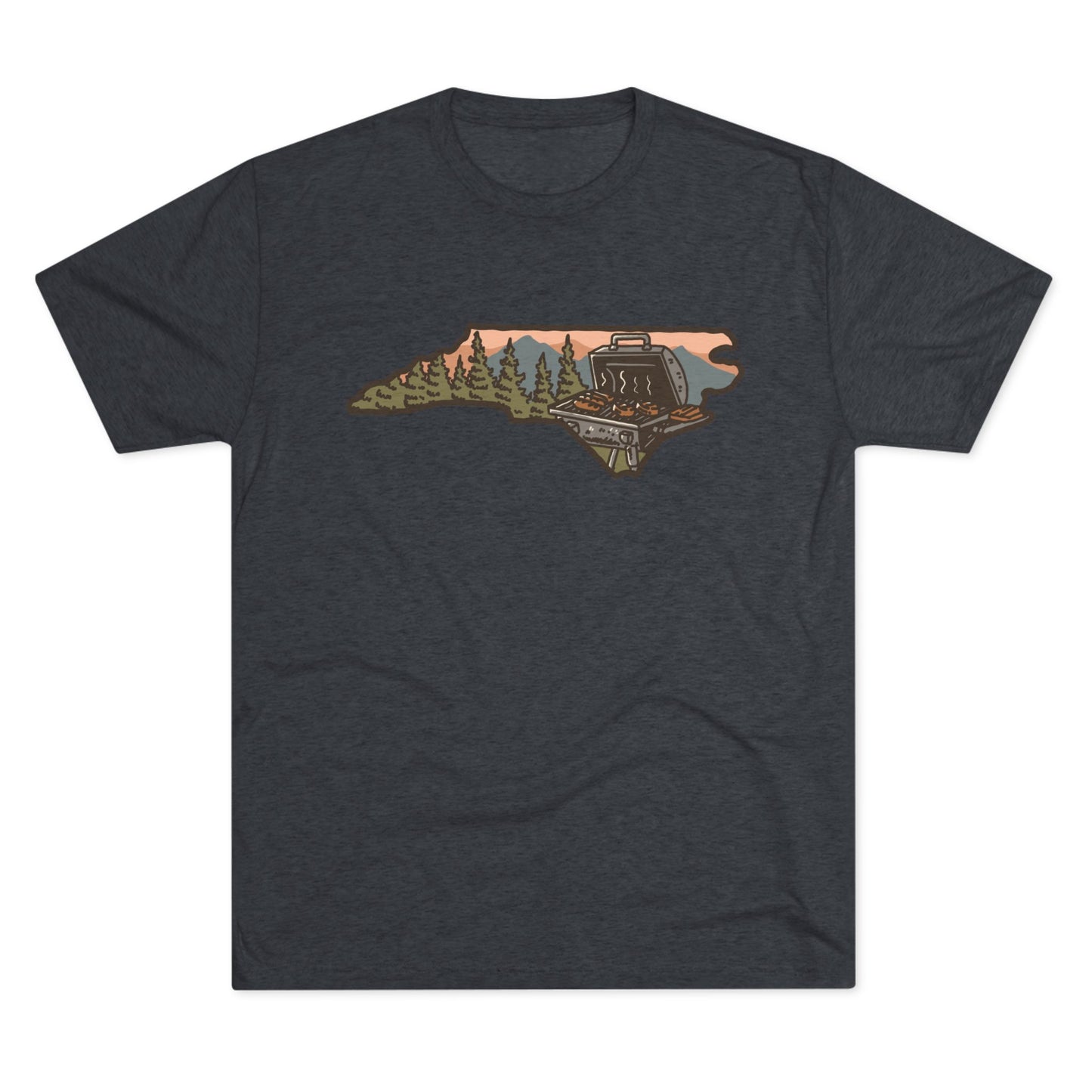 Navy T-shirt featuring a North Carolina state outline with a forest cabin, mountain backdrop, and backyard grill illustration.