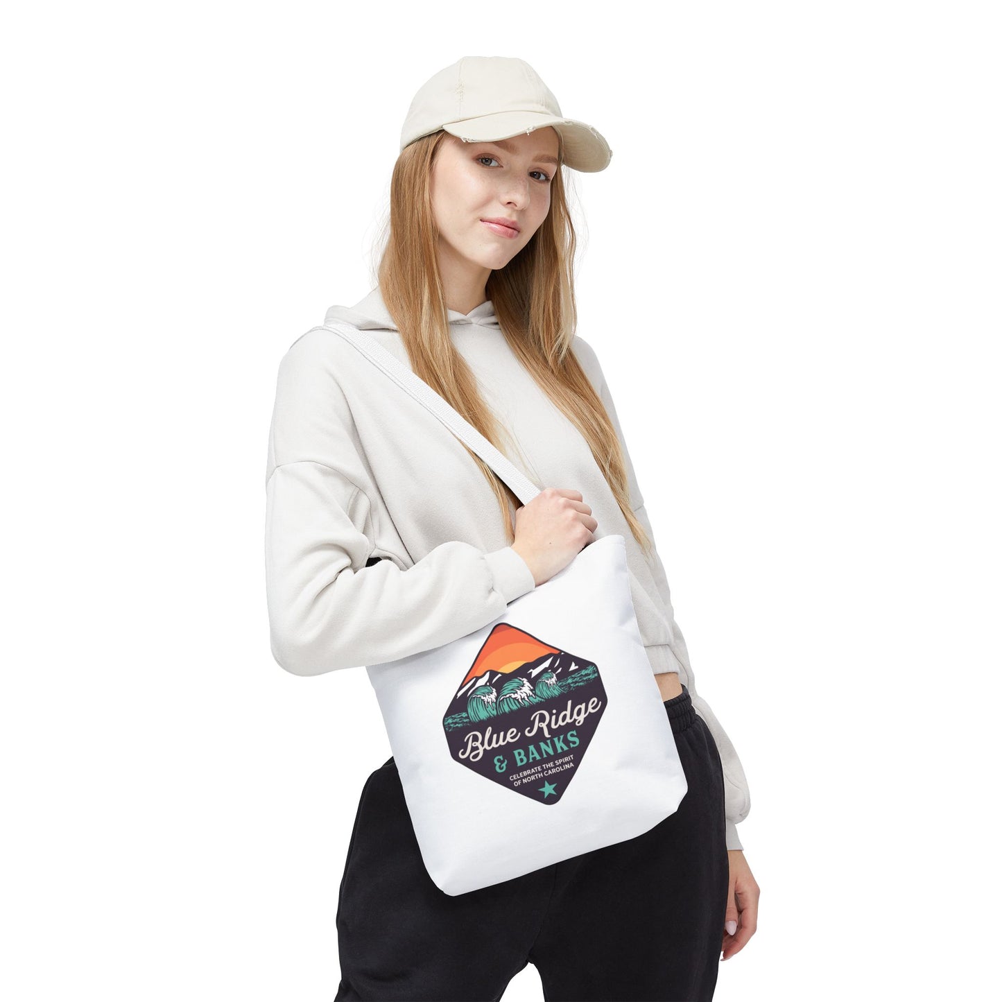 Woman holding Blue Ridge & Banks tote bag with mountain and coast logo front-facing