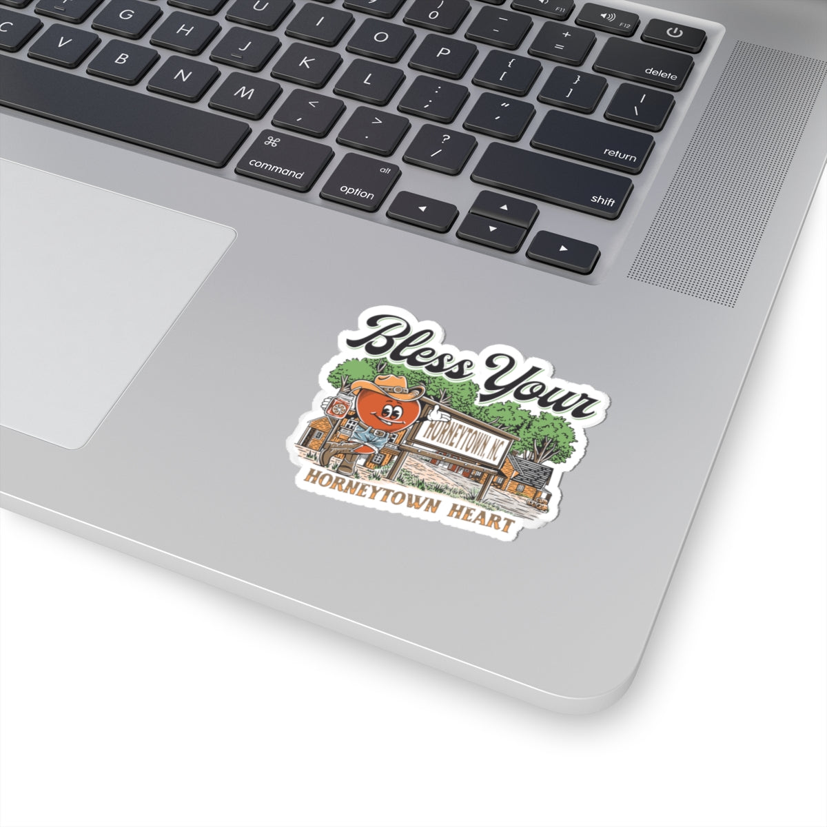 Alt text: "Bless Your Horneytown Heart Sticker – 2x2 inch Kiss-Cut Vinyl. This humorous North Carolina-inspired sticker features a playful design with nature elements, perfect for adding a touch of Southern charm to your belongings. Ideal for laptops, water bottles, or journals."