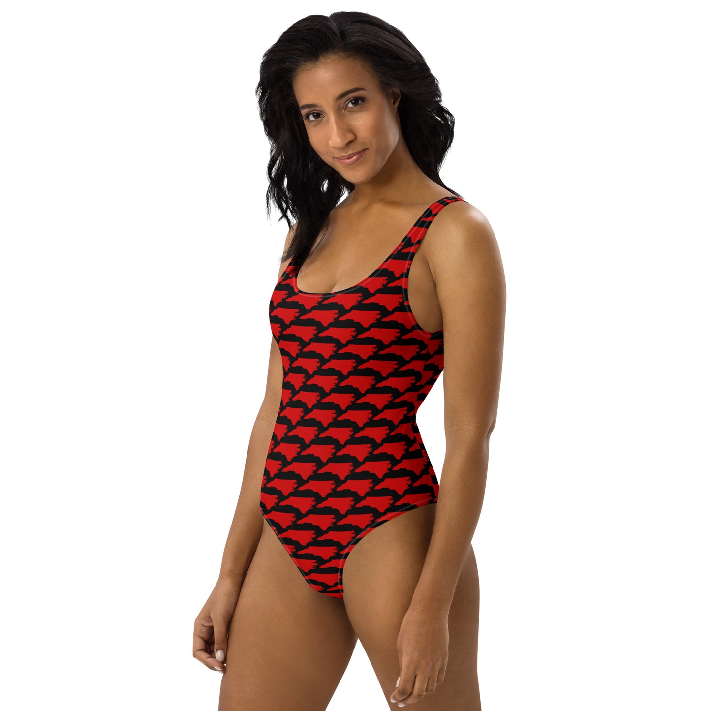 Angled front view of woman in Carolina Inferno One-Piece Swimsuit, bold red NC on black