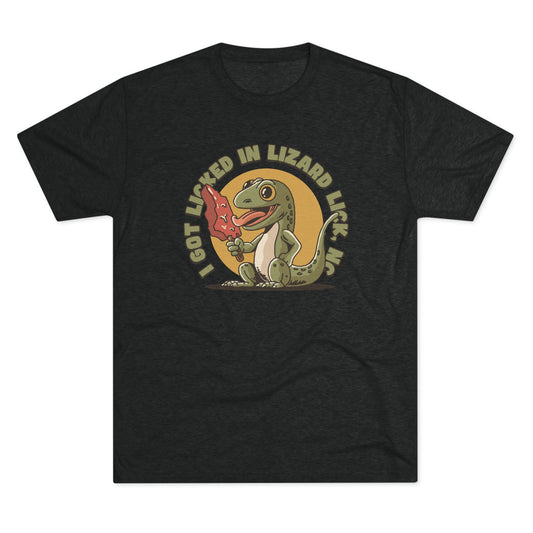 Black t-shirt with a cartoon lizard holding a red ice pop shaped like North Carolina and the text “I Got Licked in Lizard Lick, NC” on the front.