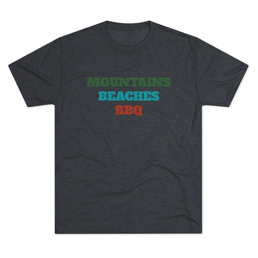 Mountains Beaches BBQ T-shirt in deep green, teal, and rust red stacked text on a dark navy tri-blend shirt.