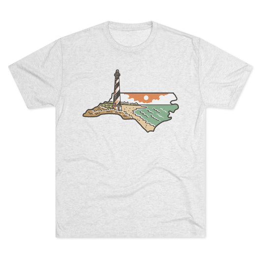 Heather white t-shirt featuring a North Carolina state outline filled with a coastal scene of a lighthouse, beach, ocean, and setting sun.